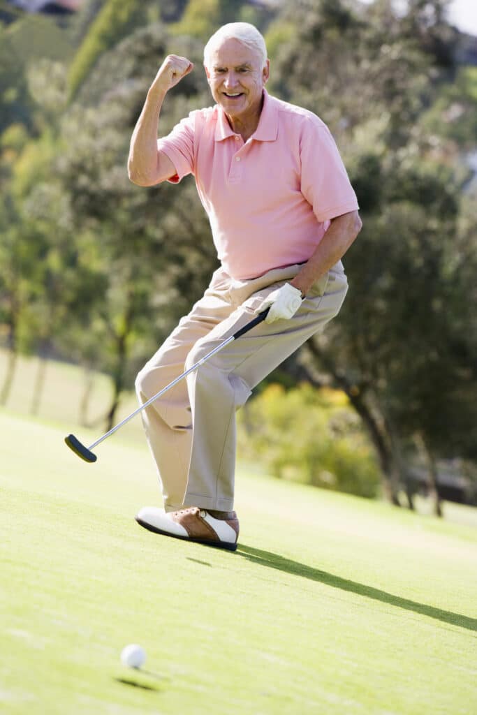 Man in pink shirt playing golf